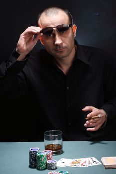 Portrait of a poker player over black background 