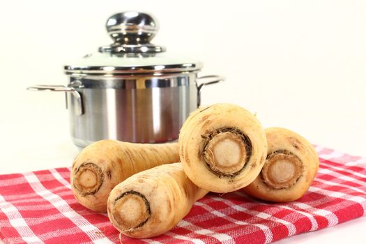 four parsnips on a red dish towel