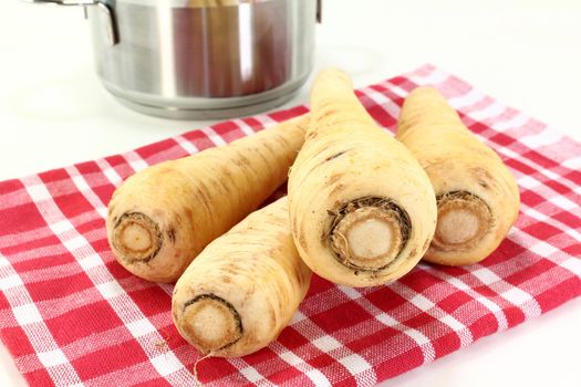four parsnips on a red dish towel