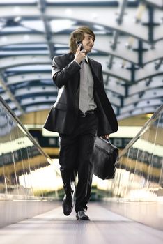 young businessman is speaking on the mobile phone in airport