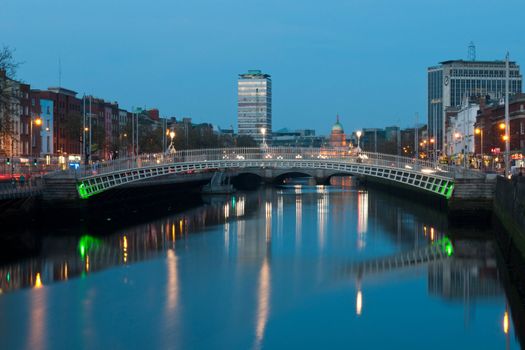 stunning nightscene with Ha'penny bridge and Liffey river, the Custom House landmark at the background (picture taken after sunset)