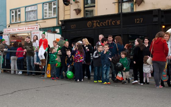 MALLOW, IRELAND - MARCH 17: unidentified crowd watching the St. Patrick's Parade on March 17, 2012 in Mallow, Ireland. This national Irish holiday takes place annually in March, event was held during the afernoon of March 17th 2012.