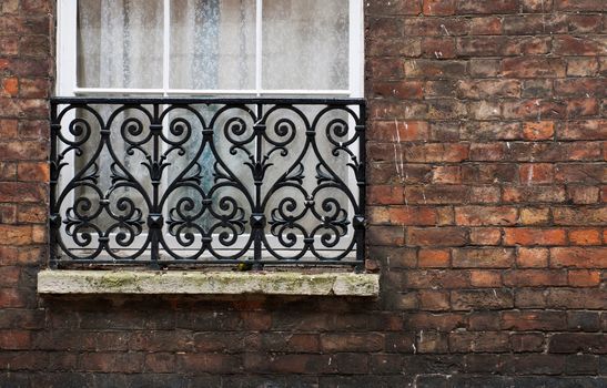 british window with gorgeous balcony and brick wall (available copy-space at the right)