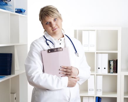 portrait of a young woman doctor with a clipboard, smiling