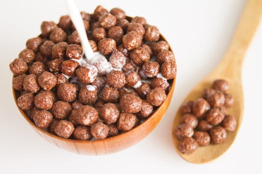 Milk pouring into bowl with chocolate balls.