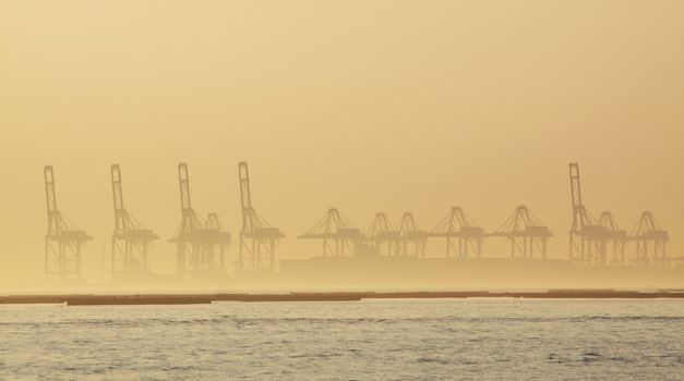 container cranes on a foggy morning