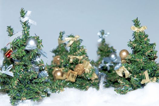 artificial christmas trees of green color with elegant ornaments and decoration