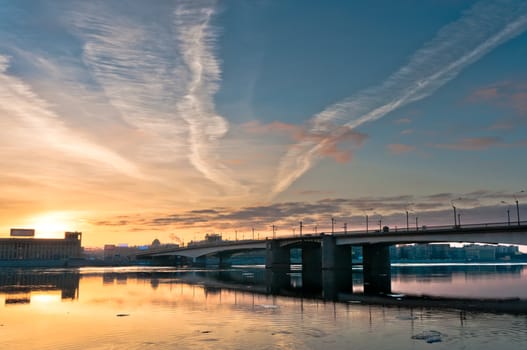 Beautiful sunrise with clouds in city over old historic bridge