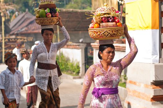 Tirta Empul, Bali, Indonesia - October 11, 2011: woman with basket on here head walking to Tirta Empul Temple to give offerings to the spirits