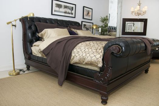 bedroom with leather bed and mirror lamps