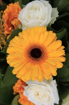 yellow gerbera in close up, part of a yellow and white floral arrangement