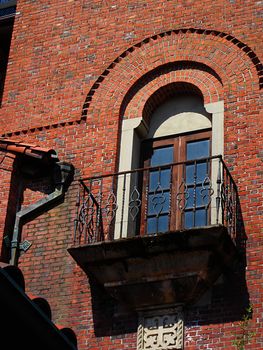 A photograph of a balcony and window detailing their beautiful architectural design.