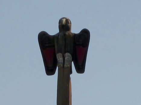 A photograph of a Native American wood carving in the shape of a bird.