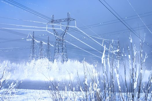 Powerful line of electricity costing in an environment of snowdrifts on a background of the blue sky
