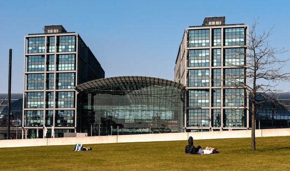 Berliners love to have a rest as soon as the sun peeps out. In the background, Berlins main station.