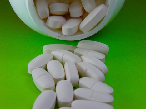 Supplement for a better life, white pills on green background