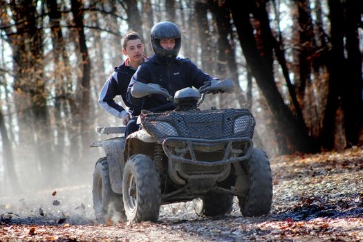 Unidentified motocross rider on ATV in the forest