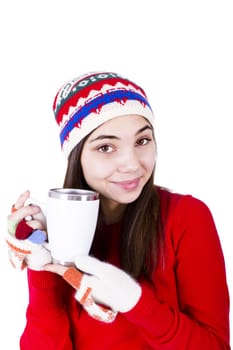 Young girl in winter clothes holding a coffe cup with copy space on it. Wearing Winter hat and fingerless glowes. Isolated on white background.
