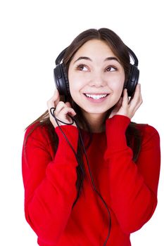 Teenager girl listening music in headphones, looking up to something. She is wearing catchy red clothing relaxed. Isolated on white background.