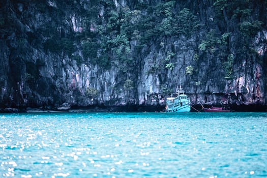 rocky shore and tour ferry in Andaman Sea, Thailand