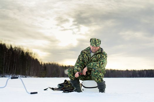 man fishing on the lake at winter