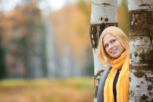 beautiful smiling blond girl in autumn park