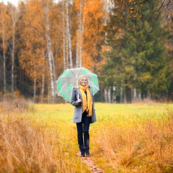 beautiful smiling blond girl in autumn forest