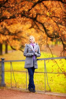 beautiful smiling blond girl in autumn park