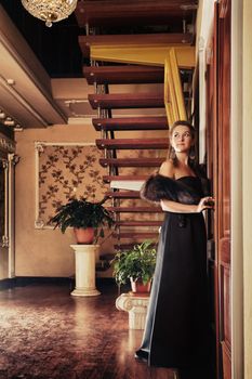 young beautiful lady standing near door in luxury interior