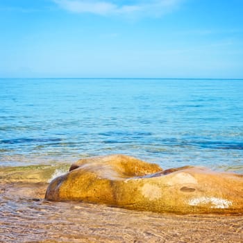 transparent sea with big stone at sunny day