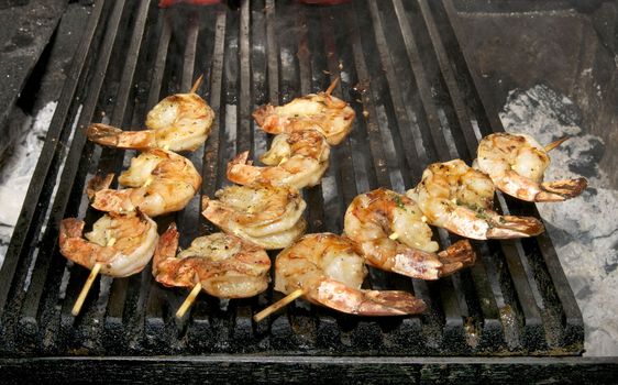 cooking shrimp kebabs on the grill in the restaurant