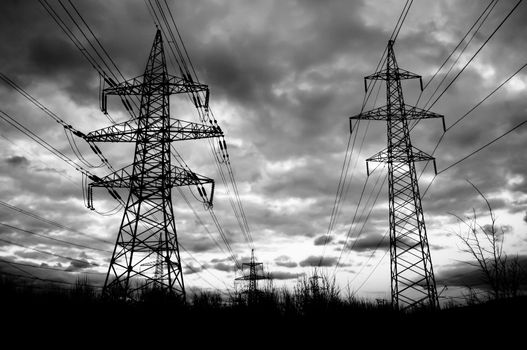 Horrible power lines silhouettes with dark cloudscape on background