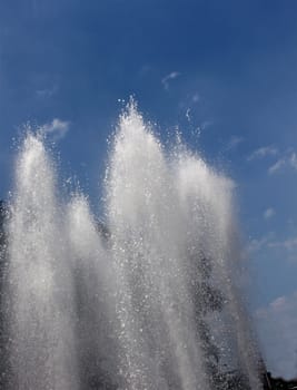 Water fountain bursting in a public park in the city.