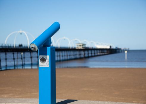 Blue Telescope with sea and pier in Southport England