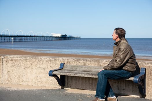 Single caucasian male looking at sea and pier in Southport England