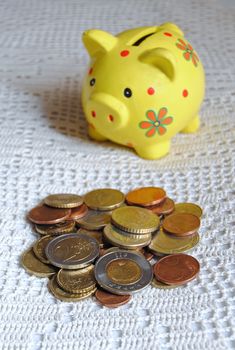 euro coins and yellow piggybank