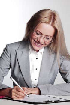 business woman writing in notebook on a gray background