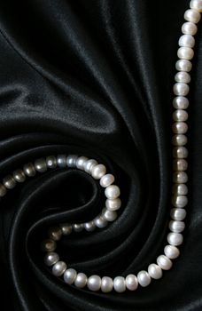 White pearls on the black silk can use as background