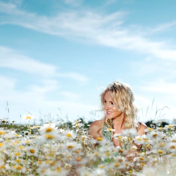 beautiful girl on the daisy flowers field 