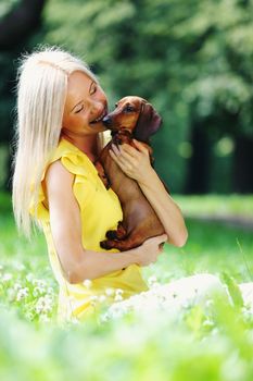 woman dachshund in her arms on grass