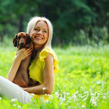 woman dachshund in her arms on grass
