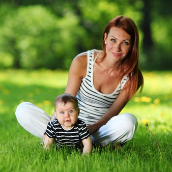 Happy mother and daughter on the green grass