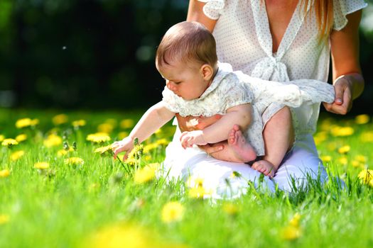 Happy mother and daughter on the green grass