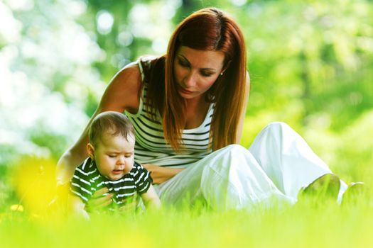 Happy mother and daughter on the green grass