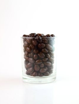 Coffee beans in a small glass on white background