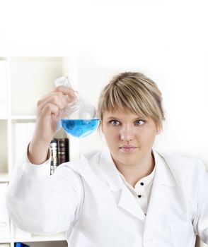 female chemist mixing liquids in test tubes, working in lab