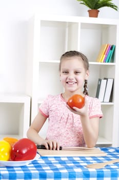 beautiful young girl cooking vegetables for a salad, working in kitchen