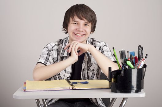 student in exams, sits at the table and reading a book