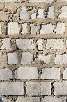 wall made of white brick closeup detail background sunlighted by sun.