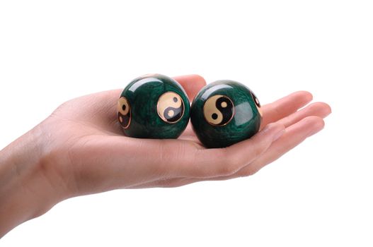 Green Chinese balls for relaxation on woman hand on white background